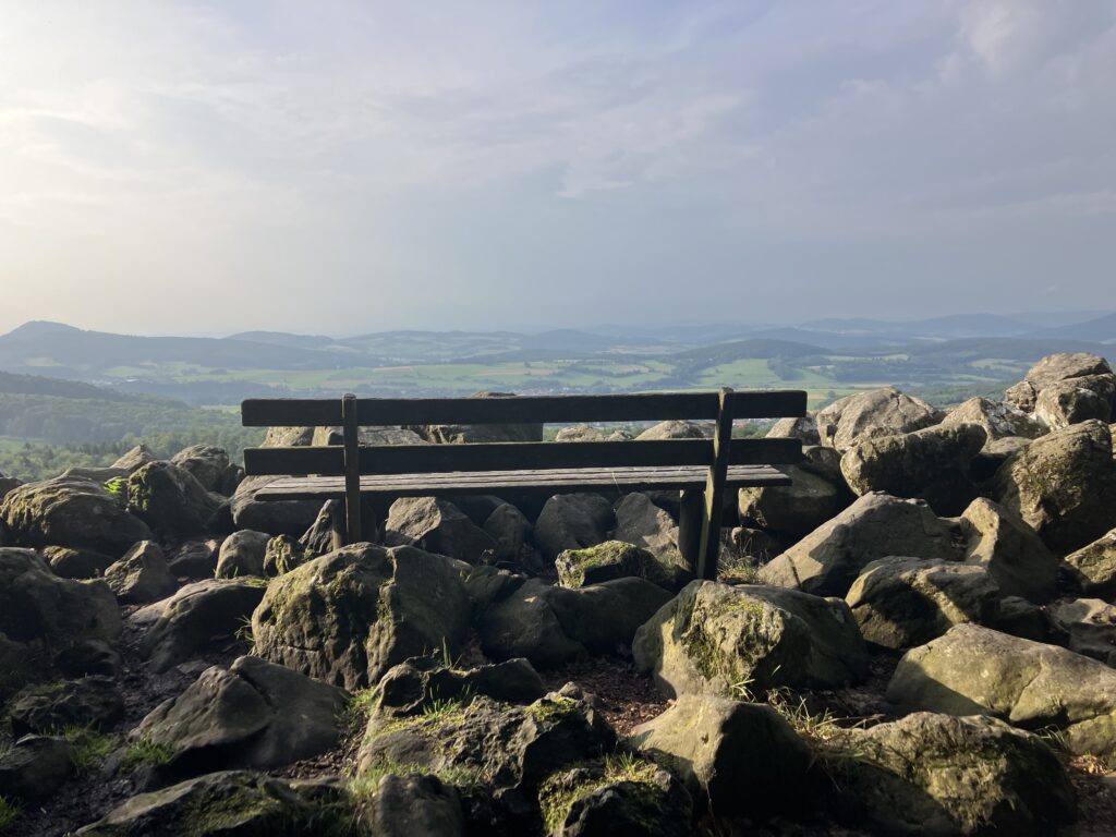 Holzbank zwischen Felsen mit weitem Blick über die Landschaft